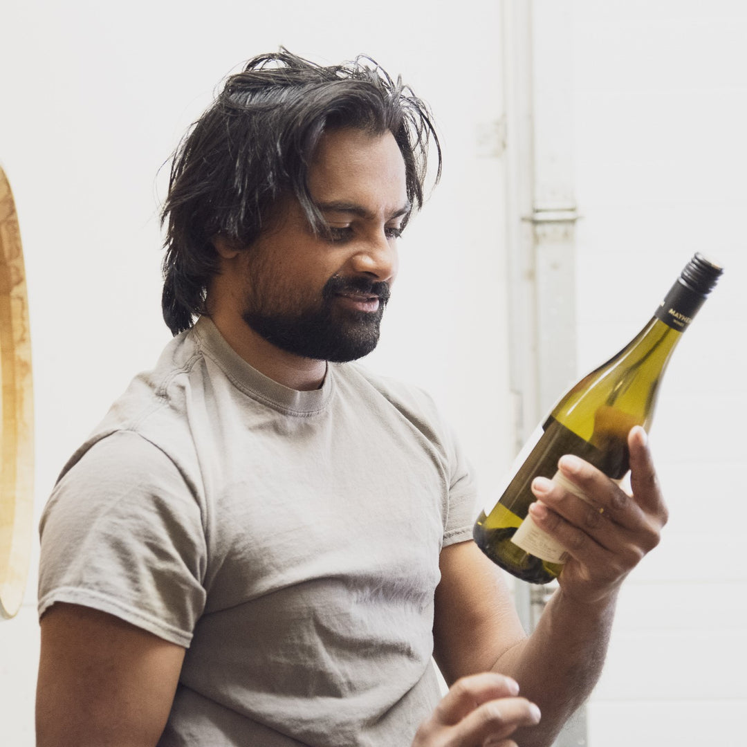 Mayhem winemaker Ajay Chavan holding a bottle of white wine